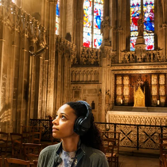 Femme dans une Basilique avec un casque audio©DR