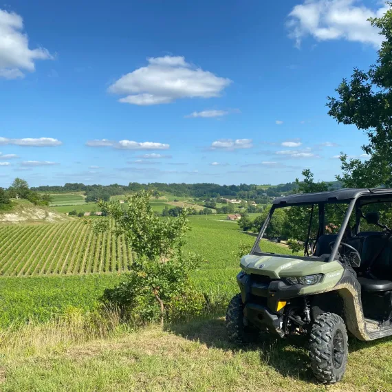 Buggy tout-terrain stationné au milieu des vignobles de Bordeaux, avec vue panoramique sur les vignes et les paysages viticoles environnants.  Nom du fichier :