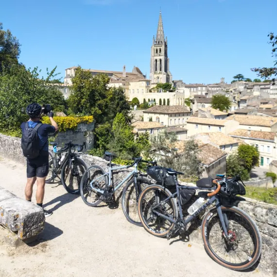 Personne profitant du point de vue sur le village de Saint-Emilion et son clocher.