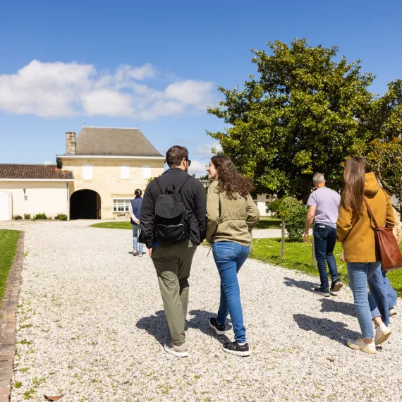 Des visiteurs découvrent un domaine viticole lors d'une visite guidée au cœur d'un vignoble.