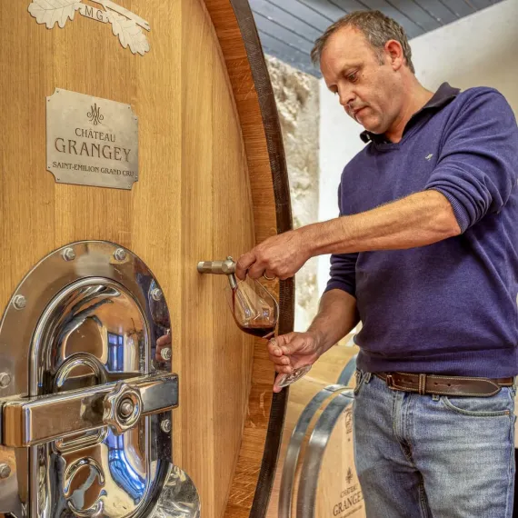 Winemaker drawing a barrel sample of red wine at Château Grangey, Saint-Émilion Grand Cru