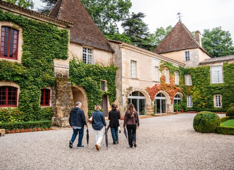 Guided group wine tour arriving at a Bordeaux château estate Château Carbonnieux