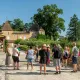 Tour group standing in front of a historic château featuring distinctive pointed towers and ochre-colored stonework, typical of Bordeaux architecture.