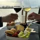 Participant dégustant un verre de vin blanc et un verre de vin rouge accompagnés d'une planches d'assortiments lors d'une croisière à Bordeaux.