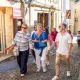 Guide touristique accompagnant un groupe de visiteurs dans les ruelles pavées du village médiéval de Saint-Émilion.