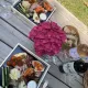 Pique-nique dans le parc du Château Mangot : planches de charcuterie, fromages, fruits, pain et bouteilles de vin rouge et rosé.