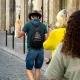 Un guide portant un sac à dos conduit un groupe de visiteurs dans une rue pavée de Bordeaux.